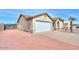 Side view of the home featuring a two-car garage and low-maintenance landscaping at 1668 E Valerie St, Casa Grande, AZ 85122