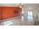 Open-concept living room with wood-look flooring leading into the kitchen, a large tv and a bold accent wall at 1668 E Valerie St, Casa Grande, AZ 85122