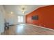 Bright living room featuring wood-look floors, a large window, and a bold accent wall with tv at 1668 E Valerie St, Casa Grande, AZ 85122