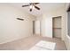 Bright bedroom featuring neutral carpet, ceiling fan, and closet with sliding doors at 17768 W Maui Ln, Surprise, AZ 85388