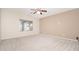 Carpeted bedroom with a ceiling fan and a view to the backyard at 17768 W Maui Ln, Surprise, AZ 85388