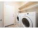 Convenient laundry room with washer, dryer, and shelving for organized storage at 17768 W Maui Ln, Surprise, AZ 85388