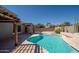 Sparkling pool with a covered patio, desert plants, and comfortable lounge area at 17768 W Maui Ln, Surprise, AZ 85388