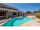 Beautiful backyard pool with a sun-drenched patio, covered porch, and desert landscaping at 17768 W Maui Ln, Surprise, AZ 85388