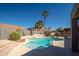 Refreshing pool with desert landscaping, palm trees, and a privacy fence at 17768 W Maui Ln, Surprise, AZ 85388