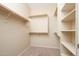 Bright walk-in closet featuring carpet and wooden racks and shelves at 17768 W Maui Ln, Surprise, AZ 85388