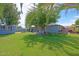 Expansive backyard with green lawn, patio area, and mature shade trees at 17801 N 43Rd Way, Phoenix, AZ 85032