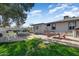 Backyard featuring an outdoor dining set, fire pit, and green space, offering an inviting area for relaxation and enjoyment at 17801 N 43Rd Way, Phoenix, AZ 85032