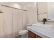 Well-lit bathroom featuring a modern sink, marble countertop, and neutral-toned shower curtain at 17902 N 93Rd Way, Scottsdale, AZ 85255