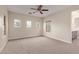 A bright, carpeted bedroom with three windows and a ceiling fan at 17902 N 93Rd Way, Scottsdale, AZ 85255