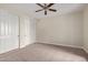 Bedroom features a carpeted floor, ceiling fan, and closet at 17902 N 93Rd Way, Scottsdale, AZ 85255