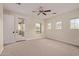 A light-filled bedroom with a ceiling fan and a door leading to a balcony at 17902 N 93Rd Way, Scottsdale, AZ 85255