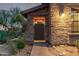 Unique stone entrance with a gated entry, landscaped surroundings, and warm lighting providing an inviting welcome at 17902 N 93Rd Way, Scottsdale, AZ 85255