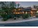 Beautiful stone home with lush desert landscaping, tiled roof, and covered patios, creating an inviting outdoor living space at 17902 N 93Rd Way, Scottsdale, AZ 85255