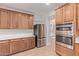 A kitchen featuring wooden cabinetry, stainless steel appliances, and light countertops at 17902 N 93Rd Way, Scottsdale, AZ 85255