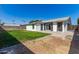 View of the backyard featuring a grass lawn, exterior walls of the home, and a large sliding door at 1827 E Jarvis Ave, Mesa, AZ 85204