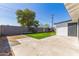 View of the backyard featuring a grass lawn with a block wall fence and mature trees at 1827 E Jarvis Ave, Mesa, AZ 85204