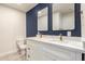 Bathroom boasts a double sink vanity with white marble counters and navy accent wall at 1827 E Jarvis Ave, Mesa, AZ 85204