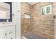 Bathroom features wood-look tiled walls, a rain shower head, and a window for natural light at 1827 E Jarvis Ave, Mesa, AZ 85204