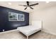 Cozy bedroom featuring a dark blue accent wall, ceiling fan, and gray tile flooring at 1827 E Jarvis Ave, Mesa, AZ 85204