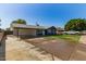 This exterior shot showcases a large driveway, covered parking, and a cozy single-story home at 1827 E Jarvis Ave, Mesa, AZ 85204