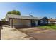 This exterior shot showcases a large driveway, covered parking, and a cozy single-story home at 1827 E Jarvis Ave, Mesa, AZ 85204