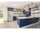 Spacious kitchen with blue cabinets, stainless appliances, and island with bar seating at 1827 E Jarvis Ave, Mesa, AZ 85204