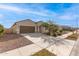 Single-story home with a well-manicured lawn, desert landscaping, and a two-car garage at 18621 W Hackamore Dr, Surprise, AZ 85387