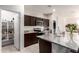 Open kitchen featuring granite countertops, dark cabinets, a pantry, and modern appliances at 18621 W Hackamore Dr, Surprise, AZ 85387