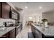 Modern kitchen with stainless steel appliances, granite countertops, and a view into the dining area at 18621 W Hackamore Dr, Surprise, AZ 85387