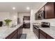 Modern kitchen with stainless steel appliances, granite countertops, and dark wood cabinets at 18621 W Hackamore Dr, Surprise, AZ 85387