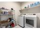 Laundry room with modern washer, dryer and storage shelving at 18621 W Hackamore Dr, Surprise, AZ 85387