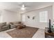 A furnished living room with tile flooring, a ceiling fan, and two windows at 18621 W Hackamore Dr, Surprise, AZ 85387