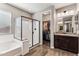 Modern bathroom featuring a glass-enclosed shower, soaking tub, double sink vanity, and walk-in closet at 19797 W Lincoln St, Buckeye, AZ 85326