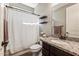 Stylish bathroom with granite countertop, decorative shelves, and shower with patterned curtain at 19797 W Lincoln St, Buckeye, AZ 85326