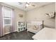 Bright Bedroom with white crib, a bookshelf filled with toys, and natural light at 19797 W Lincoln St, Buckeye, AZ 85326