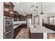 Gourmet kitchen with stainless steel appliances, granite countertops, and dark wood cabinets at 19797 W Lincoln St, Buckeye, AZ 85326