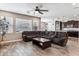 Comfortable living room with wood-look tile floors, ceiling fan, and a large sectional sofa at 19797 W Lincoln St, Buckeye, AZ 85326