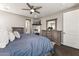 Comfortable main bedroom features stylish wood furniture, a ceiling fan, and a wall mounted television at 19797 W Lincoln St, Buckeye, AZ 85326