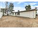 Exterior view of a white single-story home featuring a large, flat backyard and simple landscaping at 2032 W Eugie Ave, Phoenix, AZ 85029