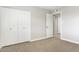 Carpeted bedroom with a closet and a door leading to the hallway at 2032 W Eugie Ave, Phoenix, AZ 85029