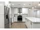 Bright, open kitchen featuring modern stainless steel appliances, white cabinetry, and an island with a quartz countertop at 2032 W Eugie Ave, Phoenix, AZ 85029