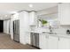 Modern kitchen featuring white cabinets, stainless steel appliances, and a view of the living area at 2032 W Eugie Ave, Phoenix, AZ 85029