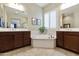 Luxurious bathroom features a soaking tub, dual vanities, and plenty of natural light at 20594 S 194Th Pl, Queen Creek, AZ 85142