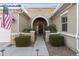 Inviting home entry with arched doorway, neutral colors, a landscaped yard, and an American flag at 20594 S 194Th Pl, Queen Creek, AZ 85142