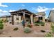 Inviting backyard patio with pergola, comfortable seating, and professionally landscaped desert environment at 20780 N Gardenia Rd, Maricopa, AZ 85138