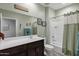 Bright bathroom with dark wood cabinets, white countertop, and tub/shower combo at 20780 N Gardenia Rd, Maricopa, AZ 85138