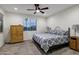 This bedroom features a ceiling fan, plush carpet, and natural light from the exterior window at 20780 N Gardenia Rd, Maricopa, AZ 85138