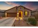 Charming single-story home with a well-manicured front yard and inviting curb appeal during a beautiful sunset at 20780 N Gardenia Rd, Maricopa, AZ 85138