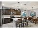 Stylish kitchen with dark wood cabinets, stainless steel appliances, a central island, and an adjacent dining area at 20780 N Gardenia Rd, Maricopa, AZ 85138